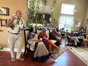 Senior man speaking at indoor house gathering