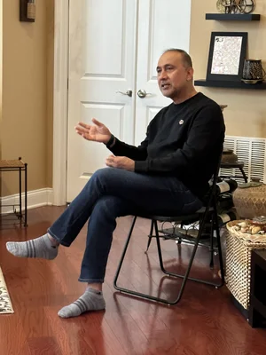 Elderly man sitting alone on a chair in a room