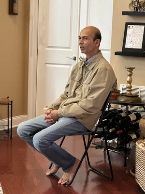 Old man sitting on a chair and listening during a group session