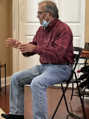 Elderly man seated and participating in a community activity